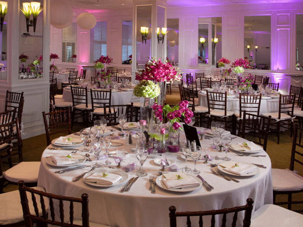 Elegant dinner reception with round tables and white chairs